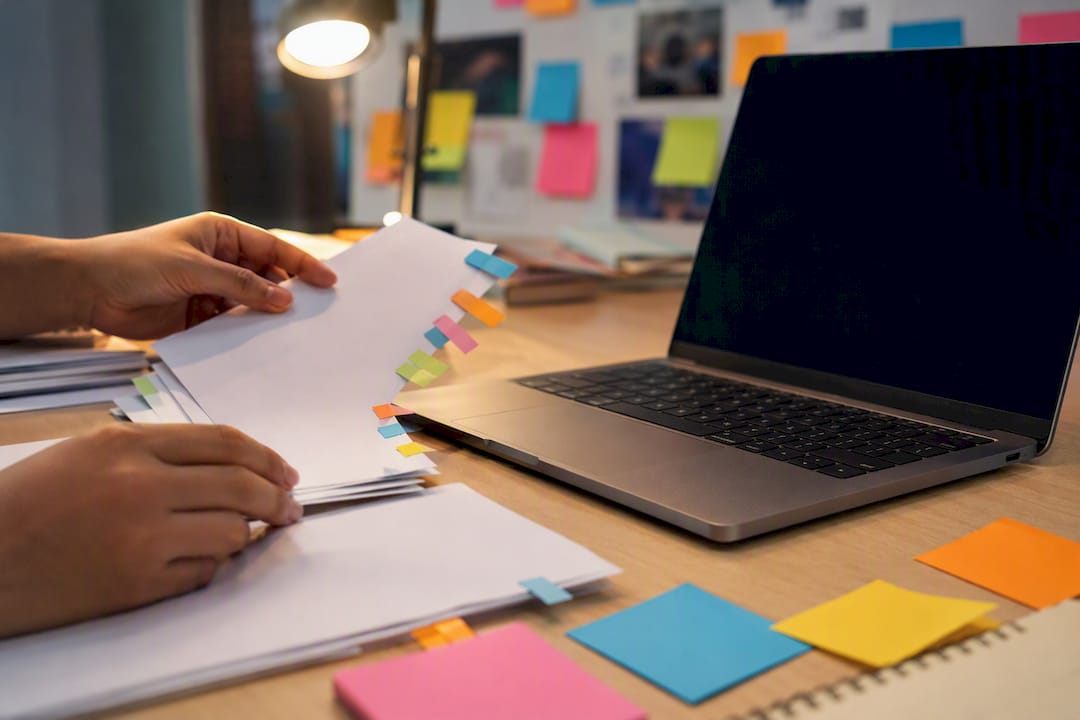 Hand arranging content post materials on table